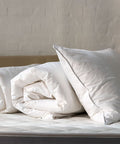 Federfreie Bettdecke und federfreies Kopfkissen aus dem Federfrei Bundle auf einem Bett arrangiert für ein gemütliches Schlafambiente.