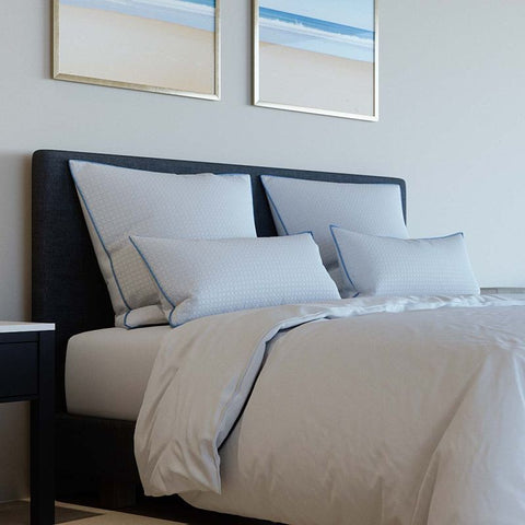 Select Kühlkissen als stilvolle Ergänzung auf einem modern bezogenen Bett mit mehreren Kissen in heller Schlafumgebung.
