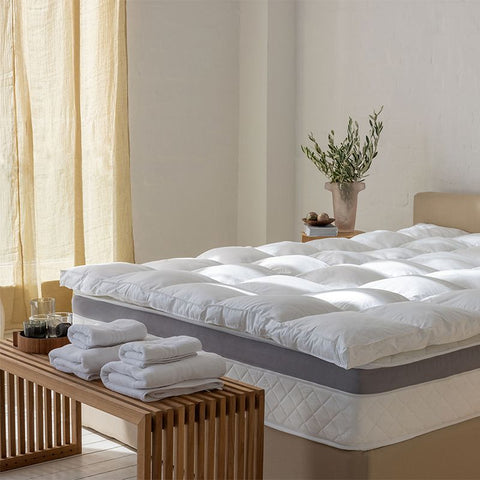 Matratzen Bundle mit federfreiem Topper auf einer hochwertigen Matratze, präsentiert in einem modernen Schlafzimmer mit wohnlicher Atmosphäre.