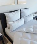 Mehrere Premium Kopfkissen Natural Hybrid auf einem modern eingerichteten Bett mit luxuriöser Bettwäsche und abgestimmtem Schlafzimmerdesign.