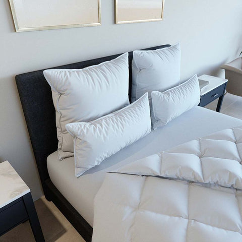 Mehrere Premium Kopfkissen Natural Hybrid auf einem modern eingerichteten Bett mit luxuriöser Bettwäsche und abgestimmtem Schlafzimmerdesign.