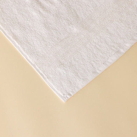 Detailaufnahme eines weißen Handtuchs aus dem Premium Luxushotel-Handtücher 4er Set mit sauber verarbeitetem Rand und dichter Baumwollstruktur.
