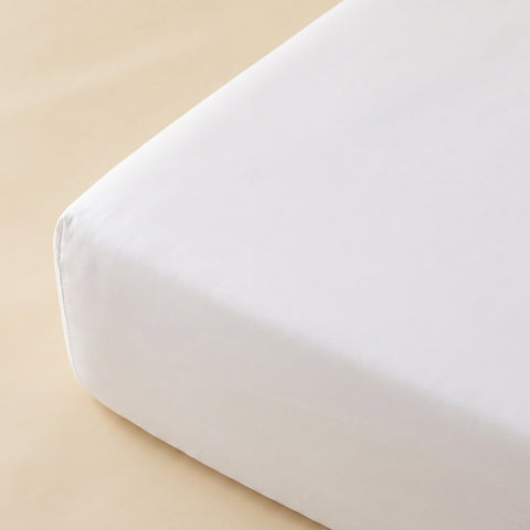 Gefaltetes Premium Spannbettlaken in Weiß mit glatter Oberfläche und hochwertiger Verarbeitung für eine elegante Bettgestaltung.