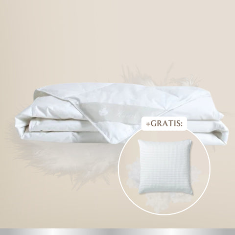 Weiße, gefaltete Bettdecke auf hellem beigen Hintergrund. In einem runden Hinweisfeld unten rechts ist ein weißes Kissen mit dem Schriftzug „+GRATIS“ abgebildet, das als kostenloses Zusatzprodukt beworben wird.